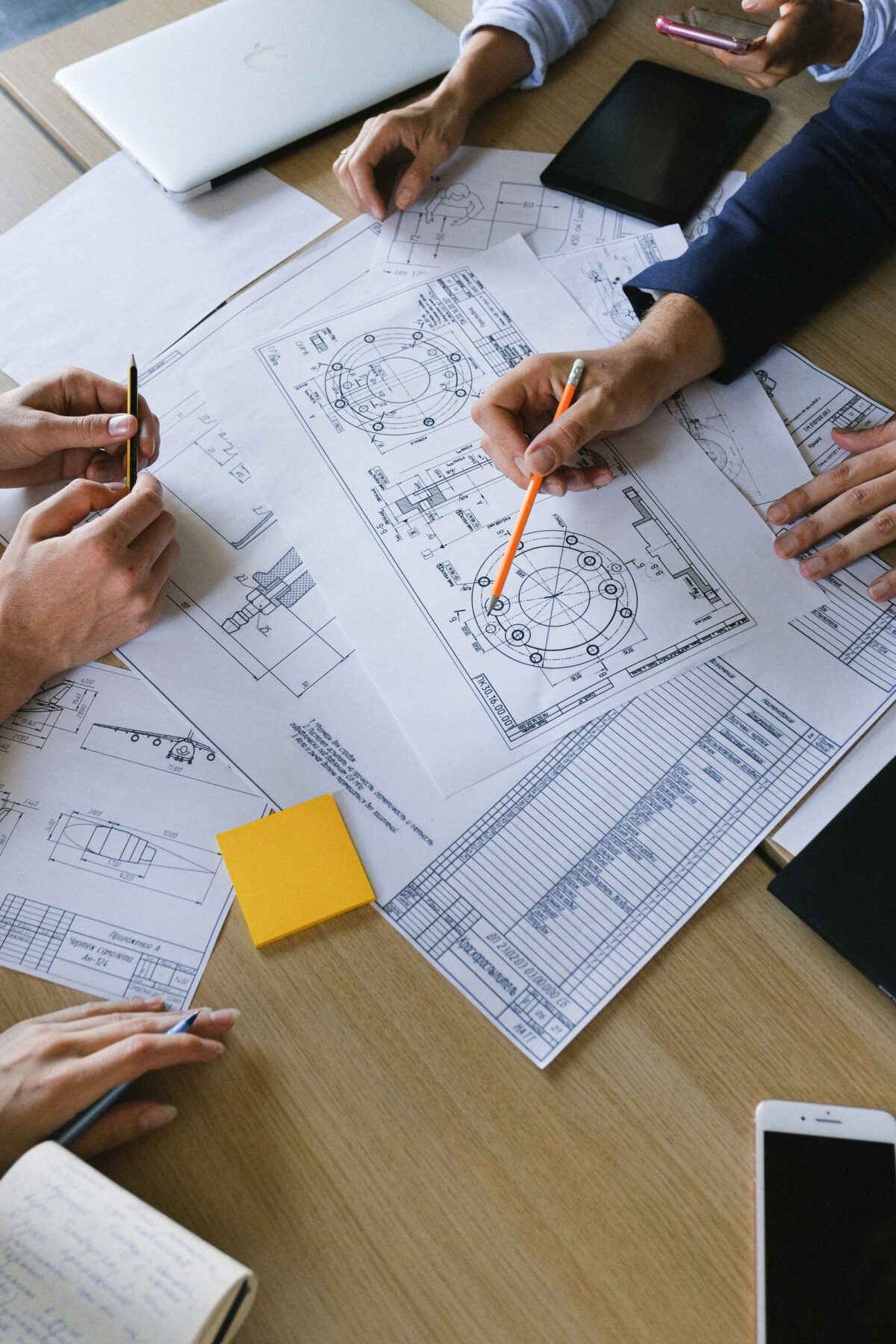 Team reviewing architectural blueprints and zoning plans at a table during a planning meeting
